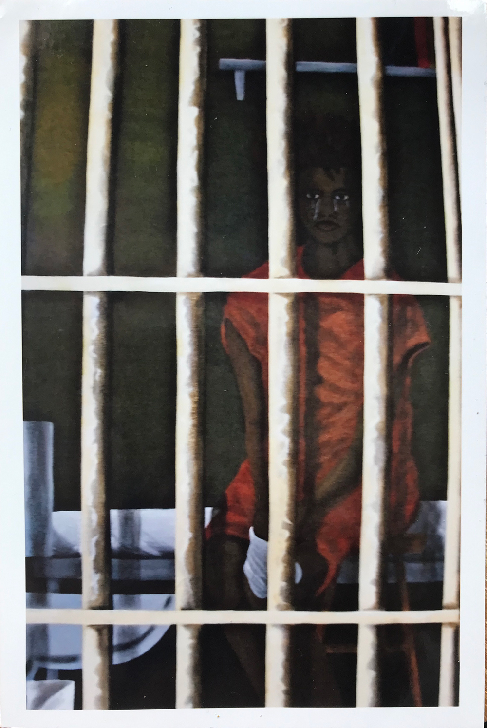 An acrylic painting of a woman in an orange uniform sitting in her cell, behind white bars. She is a Black woman and tears stream down her face. Above her is an empty shelf. To her right is a sink and toilet.